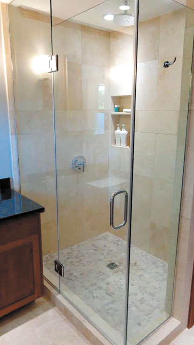 The new, custom bath was designed and built for limited space; the stall-shower tucked into the corner has travertine walls that match the bathroom flooring. 